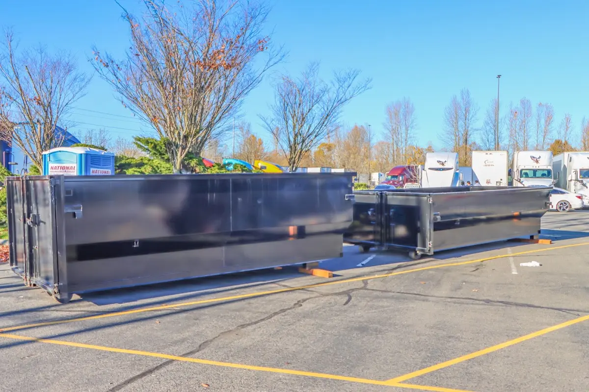 Professional dumpster rental service with roll-off container on residential driveway in Huron